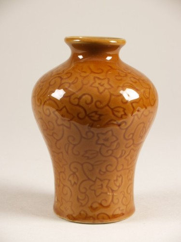 Vaas met decor van ingegrifte gestileerde ranken en voorzien van bruin glazuur